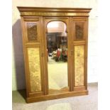 A late Victorian walnut triple wardrobe, with arch moulded mirror panelled door and two further