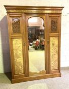 A late Victorian walnut triple wardrobe, with arch moulded mirror panelled door and two further