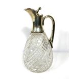 A silver mounted claret jug, hallmarked Birmingham 1919, with a pouring spout, hinged lid and scroll