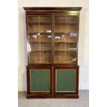 A large George III style simulated rosewood bookcase, with an moulded cornice over two glazed doors,