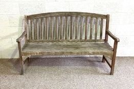 A modern garden bench, with nicely weathered patina and slatted backs
