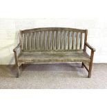 A modern garden bench, with nicely weathered patina and slatted backs