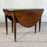An 18th century style gate leg dining table, with an oval drop leaf top on six tapered legs