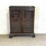 A George III style mahogany bookcase, circa 1900, with two glazed doors, opening to reveal three