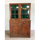 A Victorian patinated gun display cabinet, with glazed doors opening to gun storage racks, over