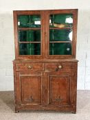 A Victorian patinated gun display cabinet, with glazed doors opening to gun storage racks, over