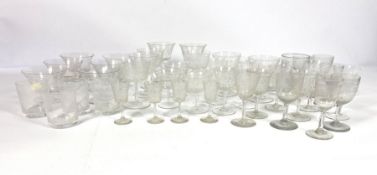 A mixed collection of etched and cut wine glasses and table wares, including champagne bowls, whisky