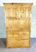 A modern pine linen press/ wardrobe, late 20th century, with two doors over four drawers