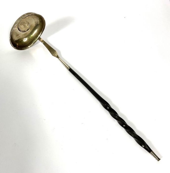 A Regency silver and baleen toddy ladle, the bowl inset with a silver 1811 token, with a twist