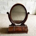 A Victorian mahogany dressing mirror, with oval moulded swing mounted plate, set on scrolled
