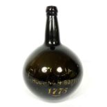 An 18th century onion shaped wine bottle, of typical form, with partly indistinct gilt lettering “
