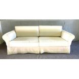 A pair of white modern sofa’s, each with two large seat cushions and curved backs, in cream/ white