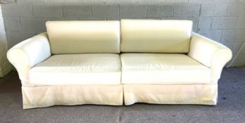 A pair of white modern sofa’s, each with two large seat cushions and curved backs, in cream/ white