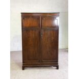 A mahogany veneered double wardrobe, 20th century, with two panelled doors, 181cm high