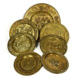 Seven assorted pressed brass alms style plaques, various sizes, embossed width figures and