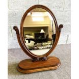 A Victorian mahogany dressing mirror, with an oval hinged plate, on oval plateau base, 84cm high