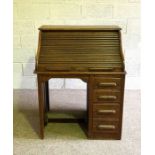 A vintage tambour front oak desk, early 20th century, with a niche and four drawers, 114cm high,