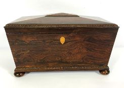 A George IV rosewood sarcophagus tea caddy, circa 1825, with beaded edges, the interior fitted