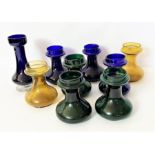 A set of vintage coloured glass candle holders and another similar