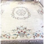 A very large vintage floral decorated wool and cotton rug, decorated in colours on a cream ground,