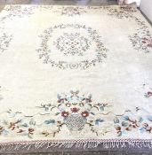 A very large vintage floral decorated wool and cotton rug, decorated in colours on a cream ground,