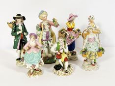 An assortment of decorative porcelain figures, including a Chelsea style figure of a seated man with