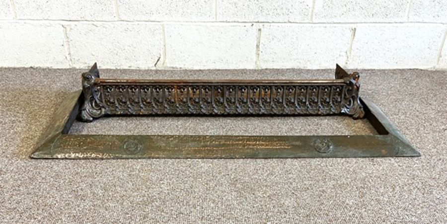 An Arts & Crafts beaten copper fire curb; together with a Victorian cast iron decorative fire