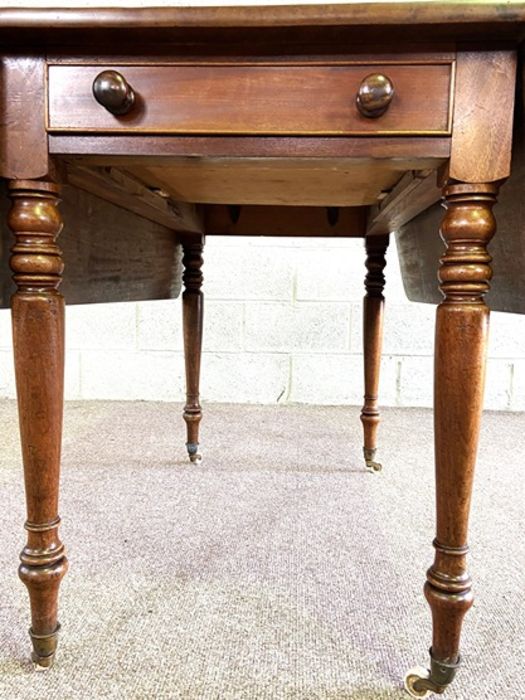 A mahogany Pembroke table, late 19th century, with a rounded drop leaf top, a single end drawer - Image 6 of 6