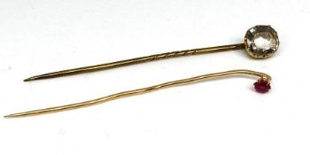 A ruby and gold stick pin, marks indistinct, with another stick pin (2)