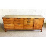 A stylish faded teak office side cabinet, circa 1960, fitted with an arrangement of drawers and