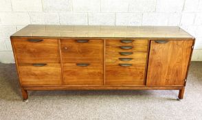 A stylish faded teak office side cabinet, circa 1960, fitted with an arrangement of drawers and