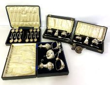 A selection of assorted silver condiment sets, including two sets with a mustard, pepper and salt,