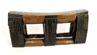 An African carved tribal art wood “pillow”, in two tones with fluted supports, 40cm wide, 18cm