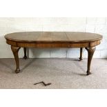 A Georgian style mahogany extending oval dining table, 20th century, with moulded oval top, two