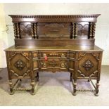 An oak Jacobean style sideboard, circa 1930, with a galleried back and twist column pilasters, the