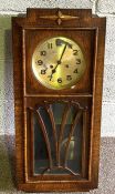 A vintage oak case wall clock, with plain case and glazed hinged door