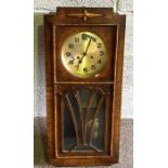 A vintage oak case wall clock, with plain case and glazed hinged door