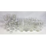 A large assortment of table glasses and other related glassware, including a set of cut glass sundae