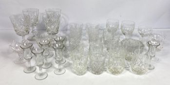 A large assortment of table glasses and other related glassware, including a set of cut glass sundae