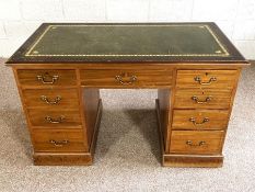 A George III style kneehole desk, circa 1900, with a green leathered top over an arrangement of nine