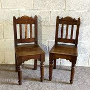 A pair of 19th century oak hall chairs, in Jacobean style, with slatted backs and turned front legs