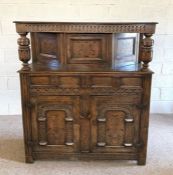 A 17th century style oak court cupboard, 20th century, with inlaid panels, the carved frieze on