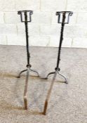 A pair of wrought iron fire dogs, with basket terminals and twist turned stems