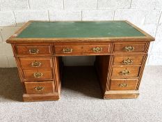 An oak twin pesestal desk, early 20th century, with leatherette inset rectangular top over