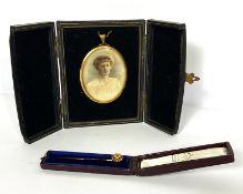A late Victorian 15 carat gold tie pin, with inset garnet, cased, 1.5g; together with a portrait