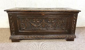 A 17th century style oak coffer, with scroll and fan carved top and panels, 50cm high, 108cm wide