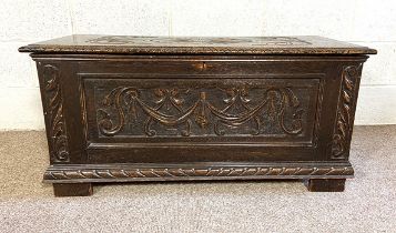 A 17th century style oak coffer, with scroll and fan carved top and panels, 50cm high, 108cm wide