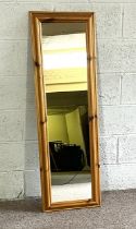 A rectangular pine framed wall mirror; together with a modern camel saddle and two small modern