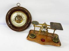A late Victorian wall mounted aneroid barometer, with 27-31 scale; also a small postage scales,