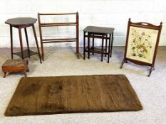 A small group of furniture including a towel rail, stool, nest of tables, rug, and octagonal plant